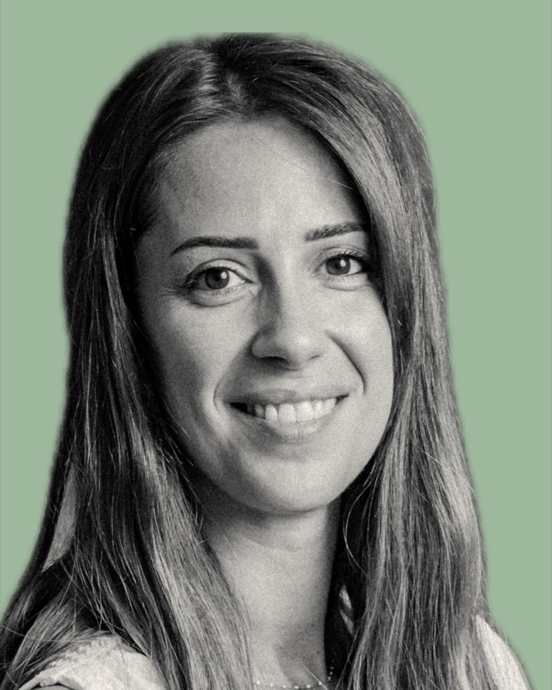 Portrait de Jade, souriante, cheveux longs, sur fond vert sauge